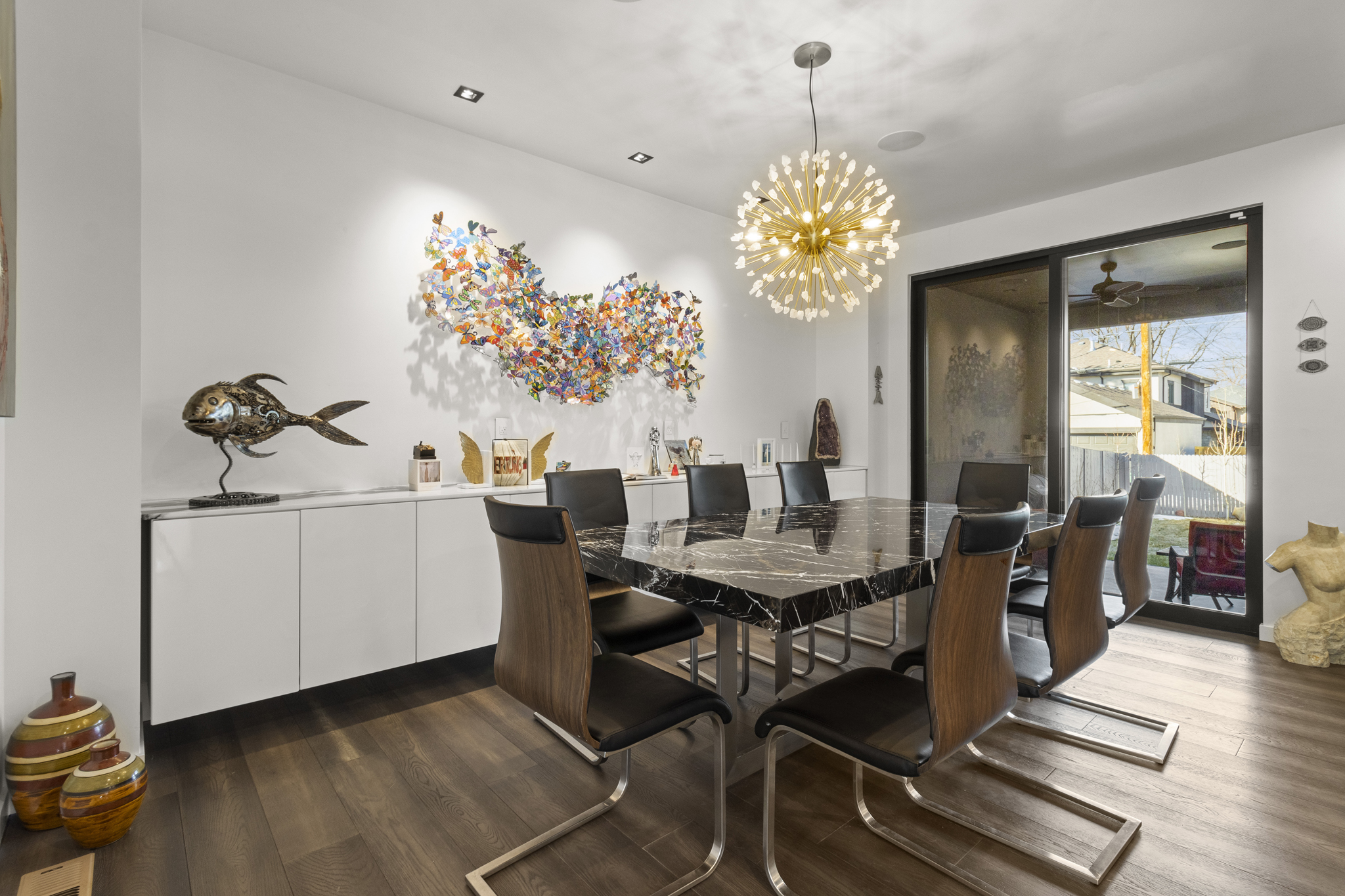 Custom-built Colorado dining room with marble table, chandelier, and artistic wall decor staging Photography in parker colorado