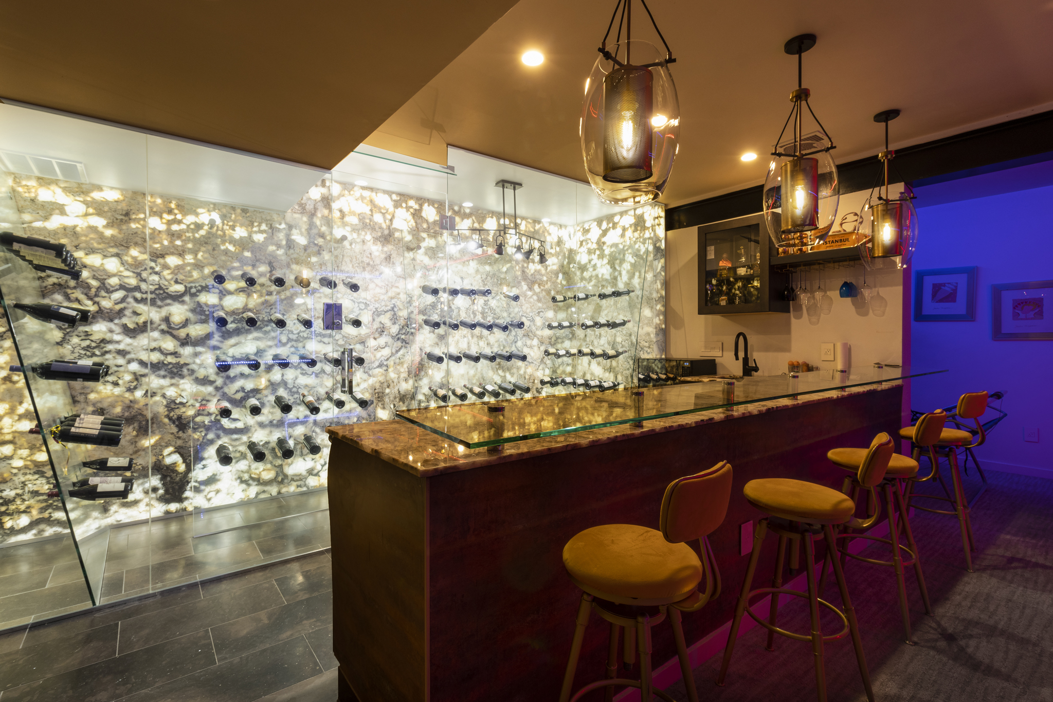 Custom-built Colorado wine bar with glass wine wall, pendant lights, and sleek bar counter Interior Design Photography