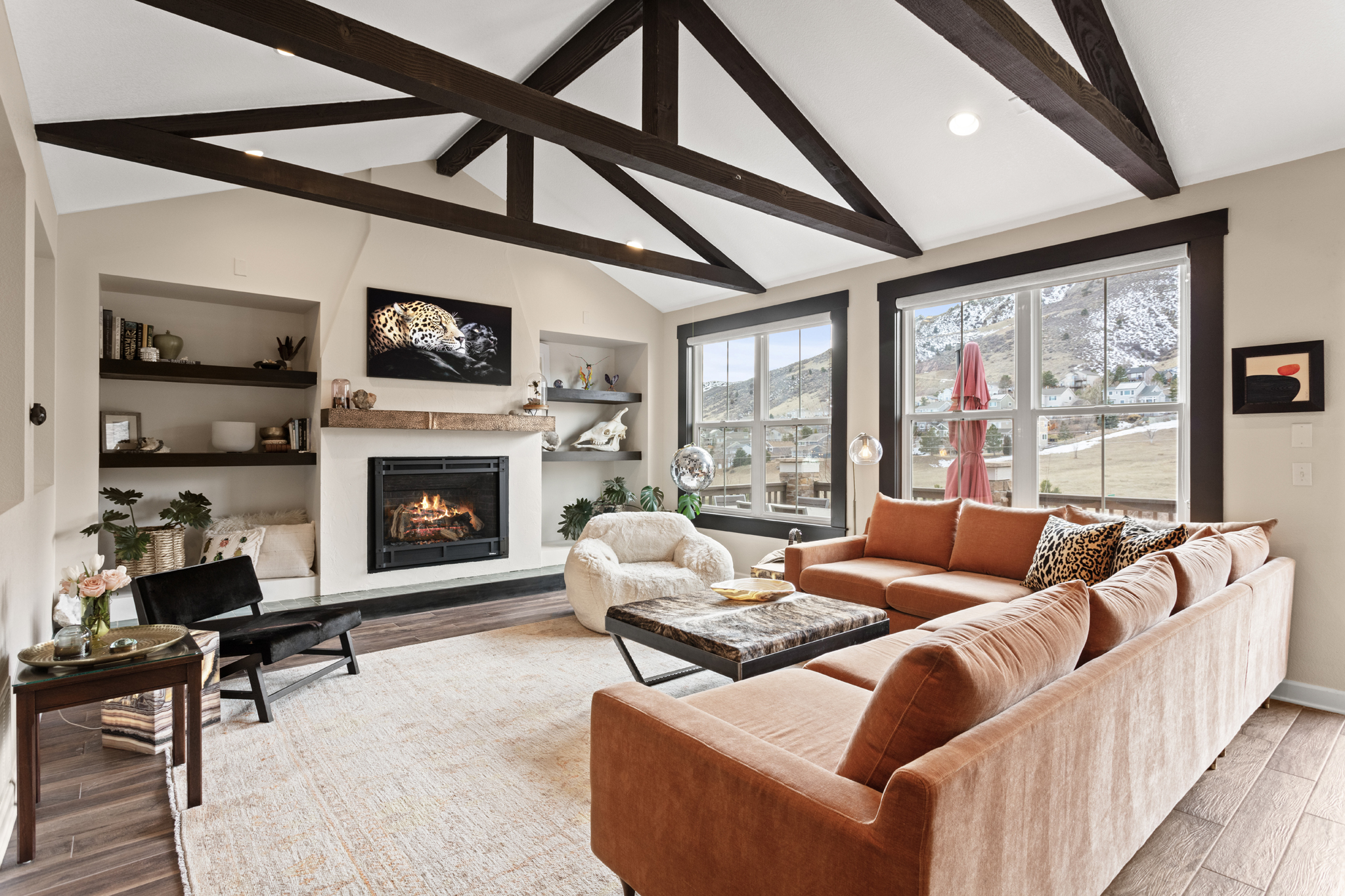 Cozy Colorado living room with vaulted beams, fireplace, and mountain view staging design Photography Golden Colorado