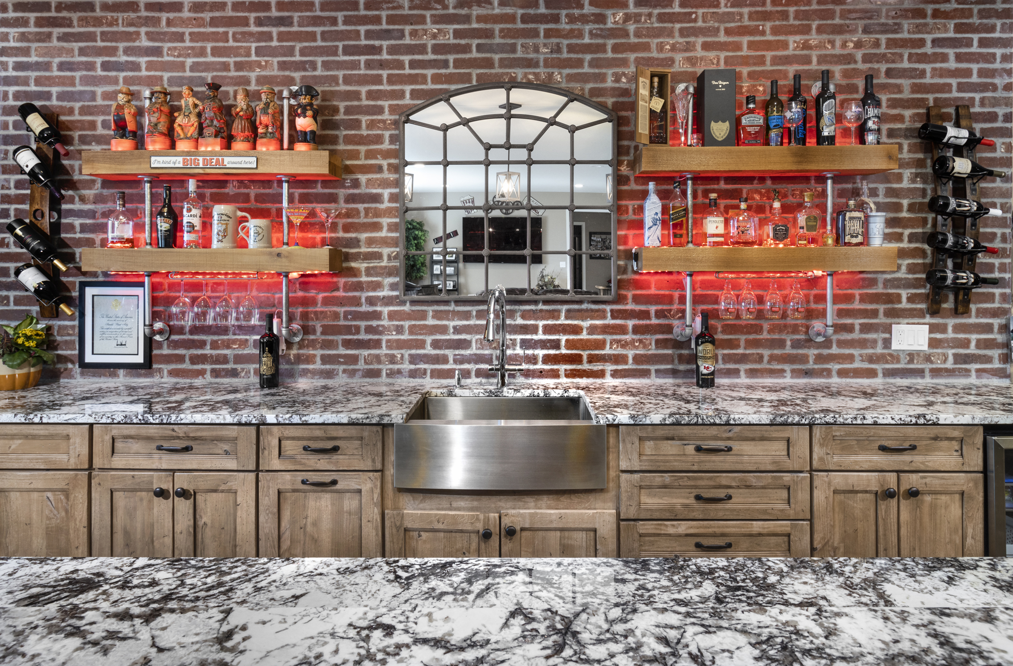 Custom-built Colorado kitchen bar with brick wall, LED-lit wooden shelves, and stainless sink interior design Photography in Hihglands Ranch Colorado